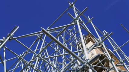 Structure of steel for building construction on sky background. Long iron pipes making geometric construction for working. Building project and engineering