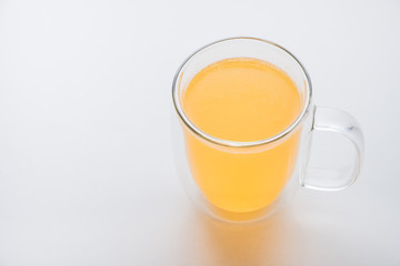 glass thermo mug of water-soluble effervescent orange tablet on a white background