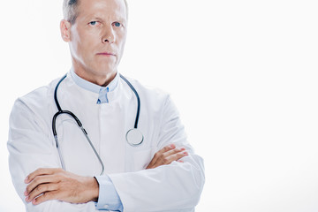 handsome doctor in white coat with crossed arms isolated on white