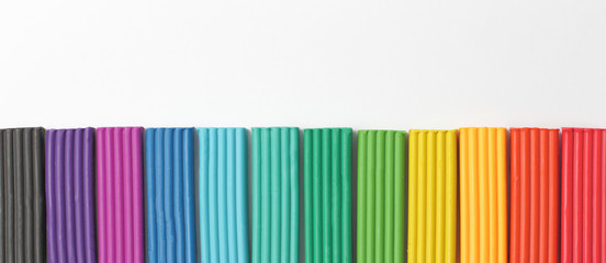 Set of multi-colored pieces of plasticine on a white background with place for text.