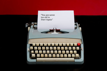 Text of you are never too old to start again on paper with old manual typewriter