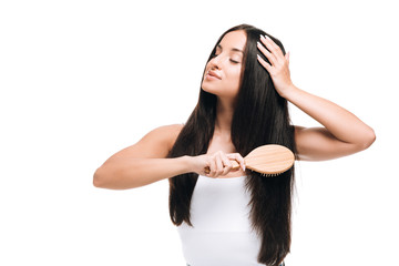 brunette beautiful woman with closed eyes brushing long straight healthy and shiny hair with comb...