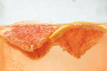 Close up view of the lemon and grapefruit slices in lemonade background. Texture of cooling sweet...
