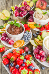 Vegan food for breakfast, snack. Homemade Sweet Hummus with strawberries, apple, crackers, grapes. Variations of different hummus dessert dips - vanilla, chocolate, caramel.