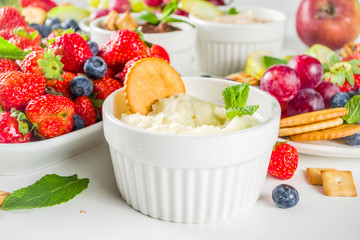 Vegan food for breakfast, snack. Homemade Sweet Hummus with strawberries, apple, crackers, grapes. Variations of different hummus dessert dips - vanilla, chocolate, caramel.