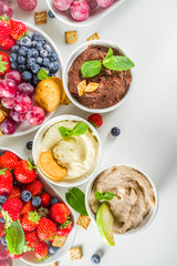 Vegan food for breakfast, snack. Homemade Sweet Hummus with strawberries, apple, crackers, grapes. Variations of different hummus dessert dips - vanilla, chocolate, caramel.