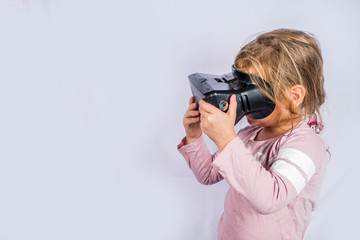 Happy little girl with virtual reality headset glasses. Innovation and VR technology, kids education concept. On white background copy space