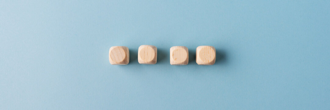 Four blank wooden dices placed in a row