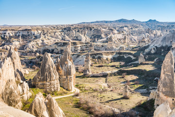 Aerial view of various rocks and Cave hotel in the valley of Goreme against blue sky, built in rock formation in national park Goreme,Cappadocia ,Turkey.