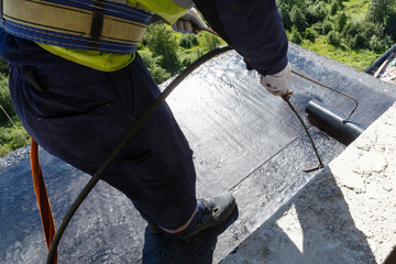 Laying waterproofing on the floor of the balcony, during the construction of an apartment building.
