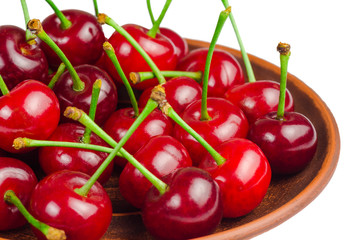 Appetizing ripe cherry in a plate on a white background