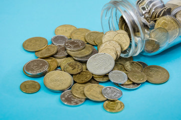 Ukrainian coins in jar on a blue background