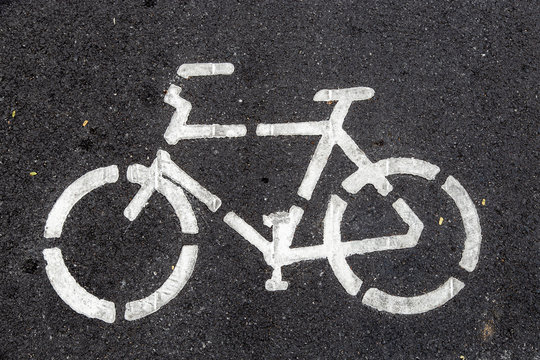 Sign bicycle on black asphalt road