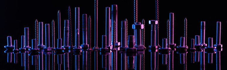 panoramic shot of diverse purple metallic screws isolated on black