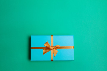 Fototapeta na wymiar Green Christmas gift box on mint background flat lay