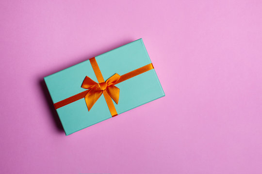 Christmas gift box on pink background flat lay