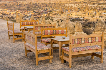 Fototapeta na wymiar An open restaurant with wood tables and chairs with background of Goreme town,Cappadocia ,Turkey.