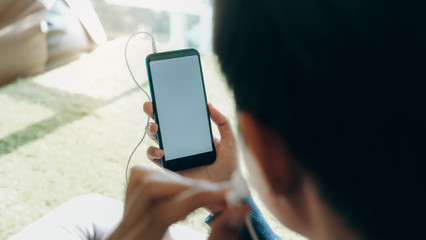 Young man relaxing listening the music from mobile phone.
