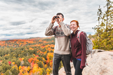 Couple looking at panorama with a binocular from the top of the rocks