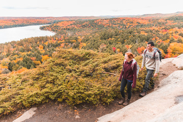 Fototapeta na wymiar Couple hiking, autumn scene, colourful trees on background