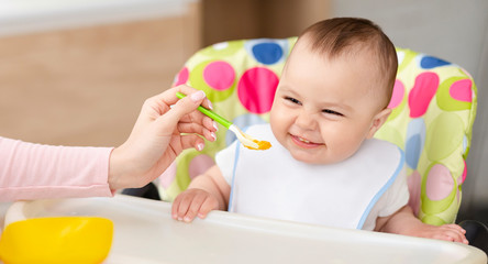 Happy toddler enjoying healthy organic meal in kitchen
