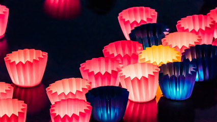 Colorful lanterns float on the lake on a festival in the night