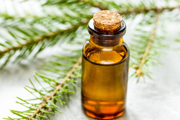 cosmetic spruce oil in bottles with fur branches on white table background