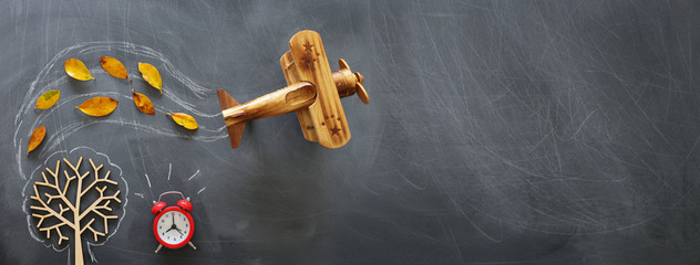 Education concept, banner of vintage airplane on a chalkboard with fall leaves
