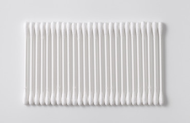 A pile of cotton swabs on a gray background. Space for text
