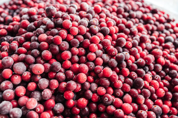 Red background made from frozen cranberries. Top view