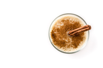 Homemade eggnog with cinnamon in glass isolated on white background. Typical Christmas dessert. Top view. Copy space