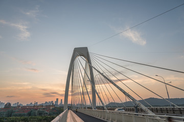 Modern large cable-stayed bridge arches perspective view at dusk background