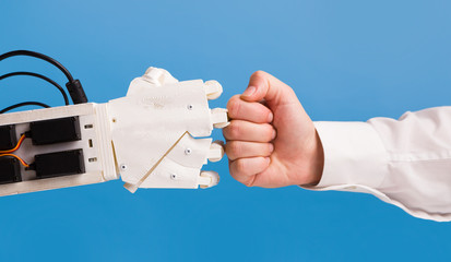Robot and human hand making fist bump gesture