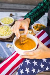 Hands dips brown bread piece into pumpkin puree. Healthy vegetarian food, vegan diet.