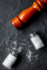 salt in glass bottle scattered on dark table background top view