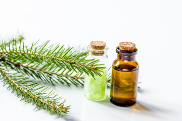 Spruce needle aromatherapy essential oils and salt in bottles on white table background