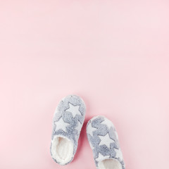Soft fluffy slippers on pink background