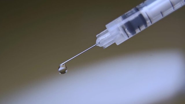medical syringe with injection solution drop.