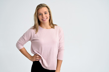 Fototapeta premium Close-up portrait of a cute caucasian blonde female student girl in pink blouse on a white background. Wide smile, happiness. It is in different poses.