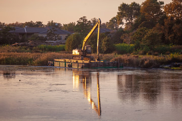 Еxcavator cleans the swamp in river pararcha.