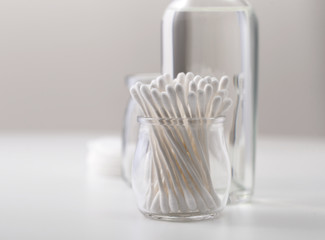 A jar of cotton buds in the bathroom on the background of cosmetics