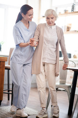 Fototapeta premium Aged woman making first steps after surgery on legs