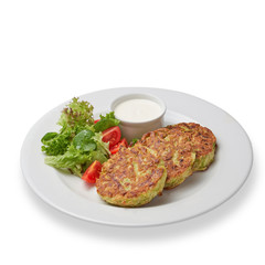 Zucchini fritters (pancakes) with vegetables and sour cream isolated on white background.