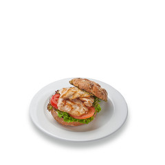 Grilled chicken burger with vegetables. Useful fitness lunch. Isolated on a white background.