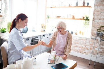 Fototapeta premium Nurse measuring blood pressure for retired lady