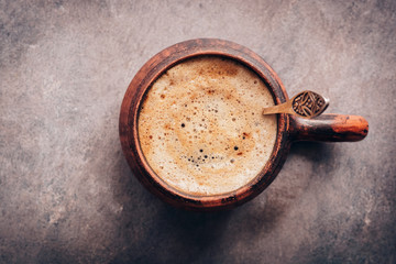 Cup of cappuccino coffee close-up on a dark vintage background. View from above.
