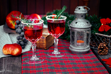 Christmas still life , two glass with red raspberry beverage decorated with rosemary , vintage old fashion style.