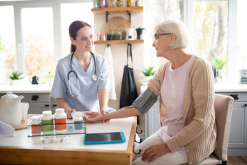 Pensioner wearing glasses speaking with nurse