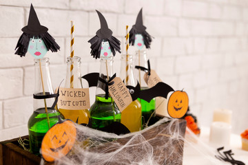 Different Halloween drinks with straws in wooden box