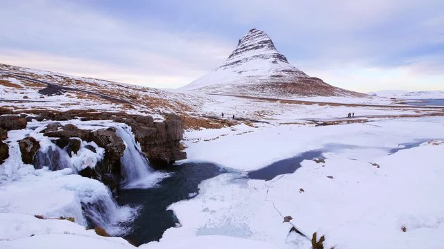Kirkjufellsfoss waterfall and Kirkfufell mountain in winter, Iceland